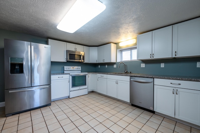 kitchen featuring white cabinetry, stainless steel appliances, a textured ceiling, and sink