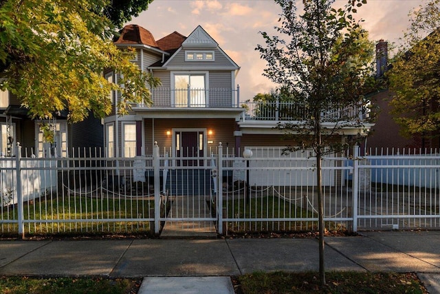 view of front of house featuring a lawn and a balcony