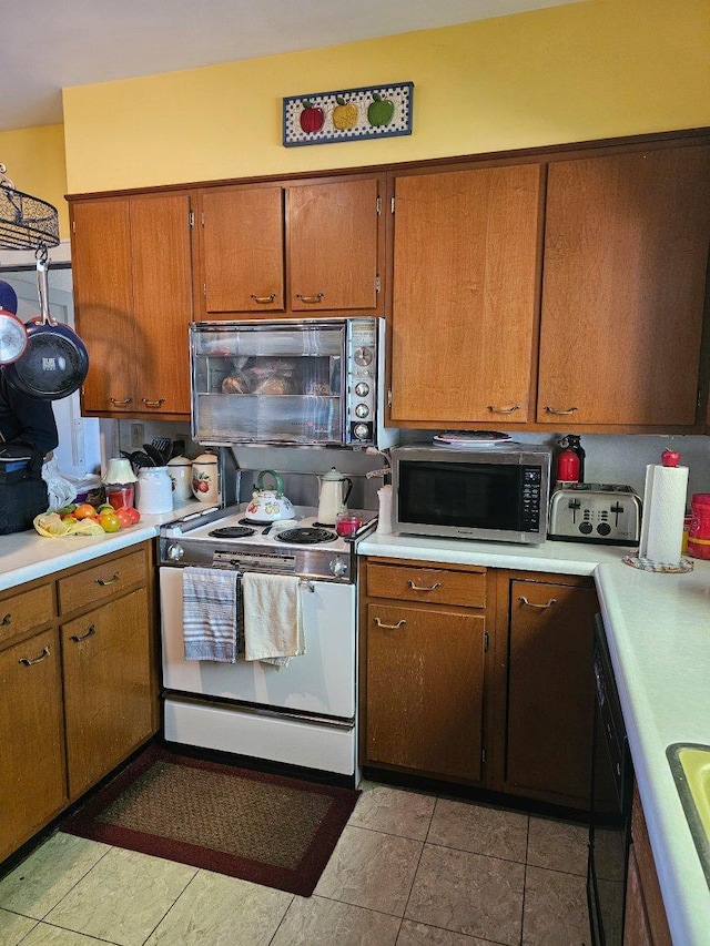 kitchen with sink, black appliances, and light tile patterned floors