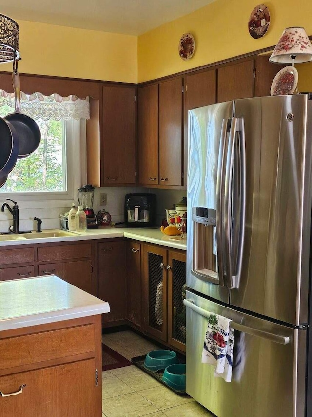 kitchen featuring sink, stainless steel fridge, and light tile patterned floors