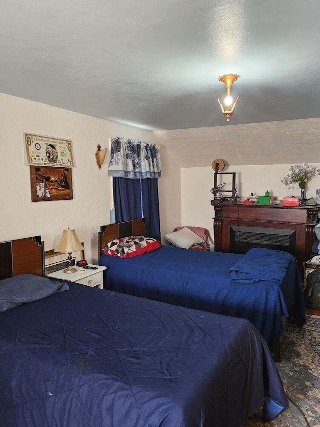 bedroom featuring vaulted ceiling and a textured ceiling