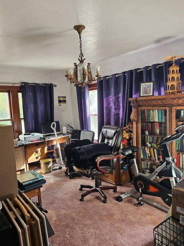 carpeted home office with a notable chandelier and plenty of natural light