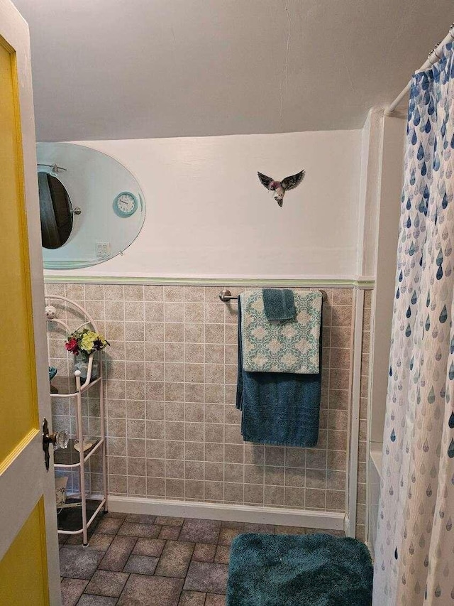 bathroom with walk in shower and tile walls