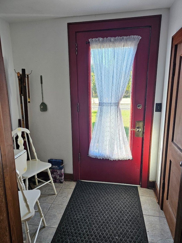 doorway to outside with light tile patterned floors