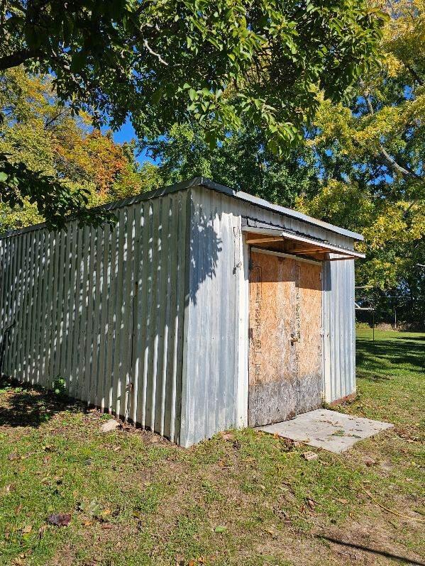 view of outbuilding featuring a lawn