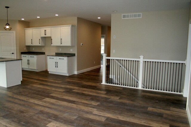 kitchen with dark wood-type flooring, decorative light fixtures, and white cabinets