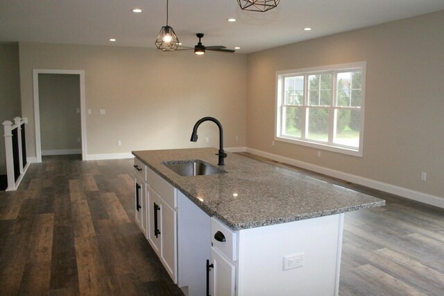 kitchen featuring a center island with sink, white cabinetry, dark hardwood / wood-style floors, pendant lighting, and sink