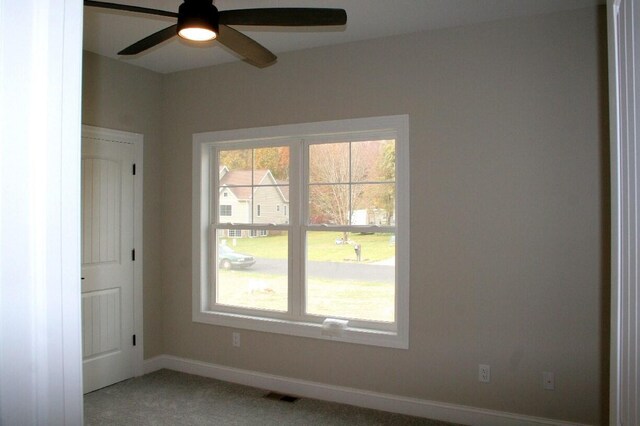 carpeted spare room featuring ceiling fan