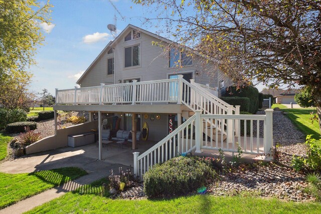 rear view of property with a deck and a patio