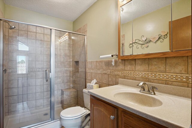 bathroom featuring vanity, toilet, walk in shower, and tile walls