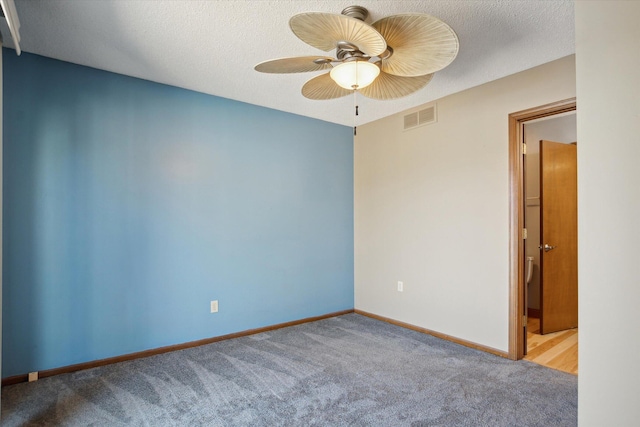 unfurnished room with ceiling fan, a textured ceiling, and light colored carpet