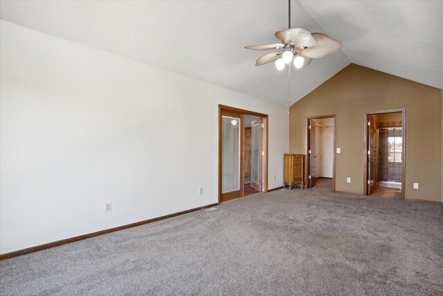 unfurnished bedroom with ensuite bath, a spacious closet, carpet flooring, high vaulted ceiling, and ceiling fan