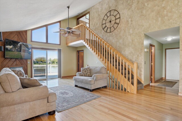 living room featuring light wood-type flooring, high vaulted ceiling, and ceiling fan