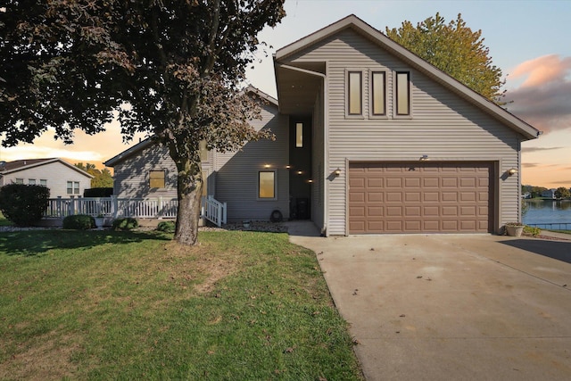 view of front of property with a garage and a lawn