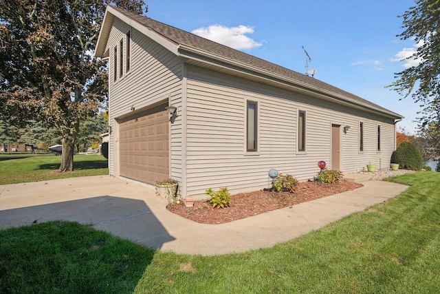 view of side of property with a yard and a garage