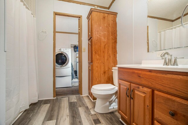 bathroom featuring a textured ceiling, hardwood / wood-style floors, toilet, vanity, and ornamental molding