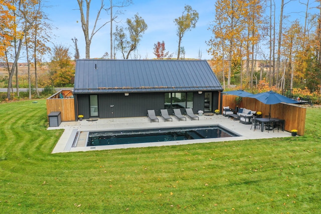 back of house with a patio area, a fenced in pool, and a lawn