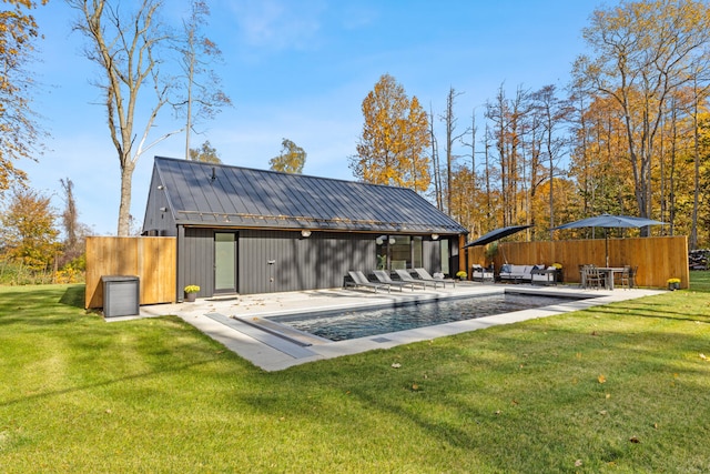 back of property featuring a fenced in pool, a patio area, and a yard