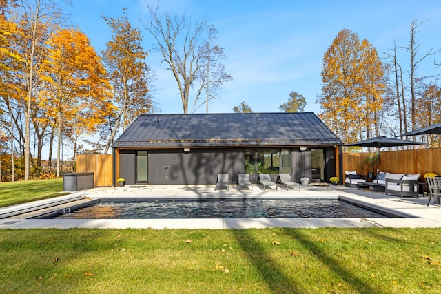 rear view of house with a fenced in pool, a patio area, a lawn, and an outdoor living space