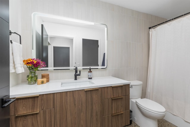 bathroom with toilet, walk in shower, vanity, and tile walls