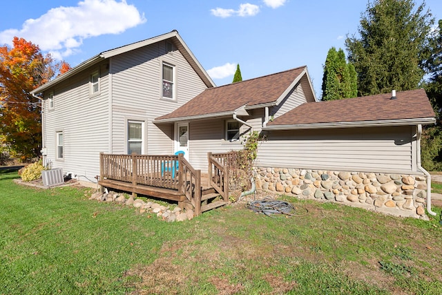 back of property featuring cooling unit, a wooden deck, and a lawn