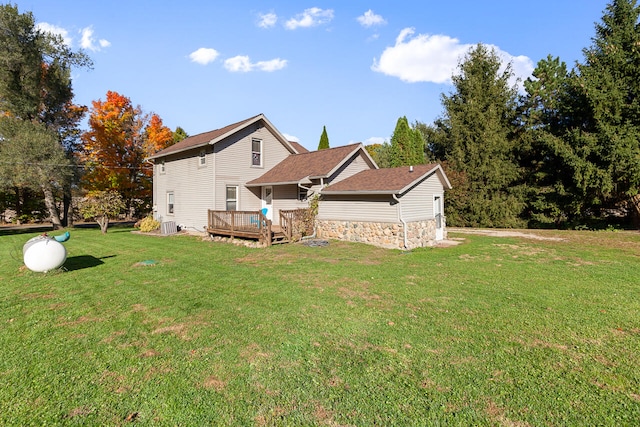 back of house featuring a wooden deck and a lawn