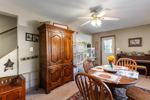 dining room featuring ceiling fan and light carpet