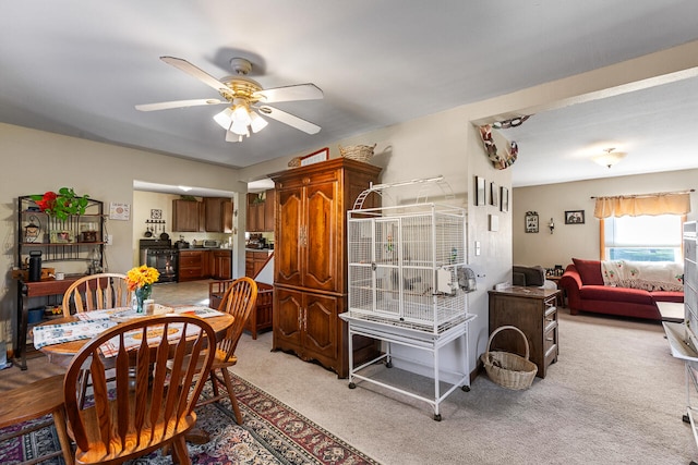 carpeted dining space with ceiling fan