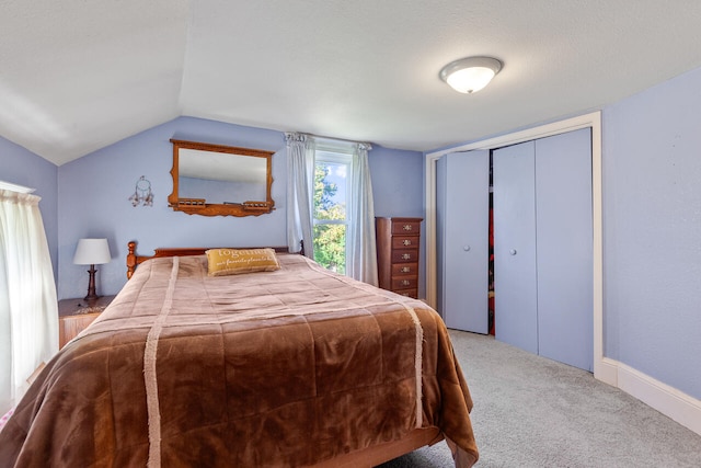 carpeted bedroom featuring vaulted ceiling and a textured ceiling