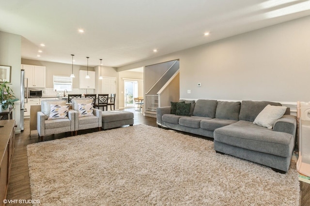 living room featuring sink and dark hardwood / wood-style floors