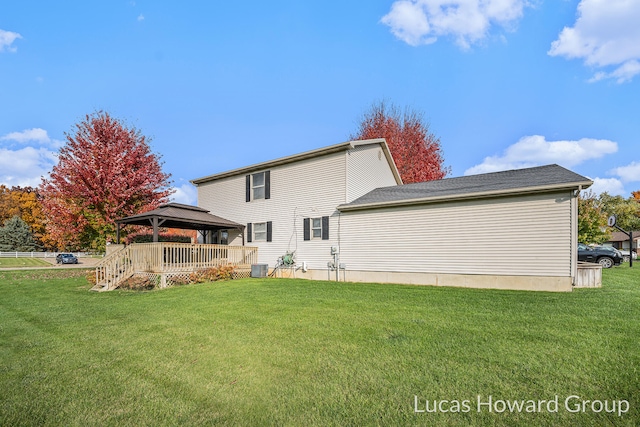 back of property featuring a gazebo, cooling unit, and a lawn