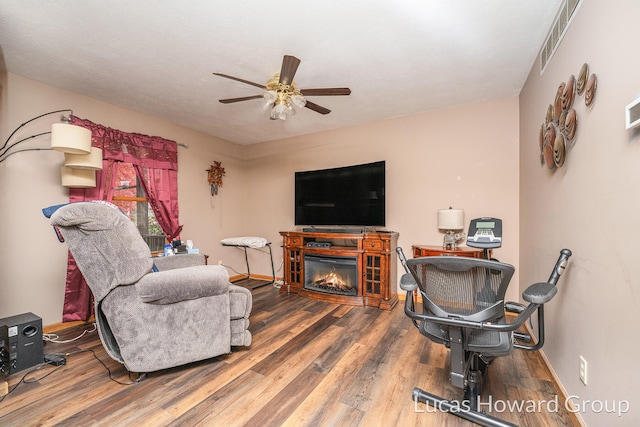 living room featuring hardwood / wood-style floors and ceiling fan