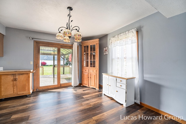 unfurnished dining area with a notable chandelier, a healthy amount of sunlight, and dark hardwood / wood-style flooring