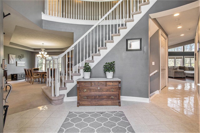 stairway featuring a high ceiling, a notable chandelier, and tile patterned flooring