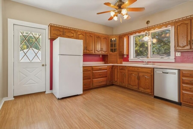 kitchen featuring ceiling fan, dishwasher, light hardwood / wood-style floors, sink, and white refrigerator