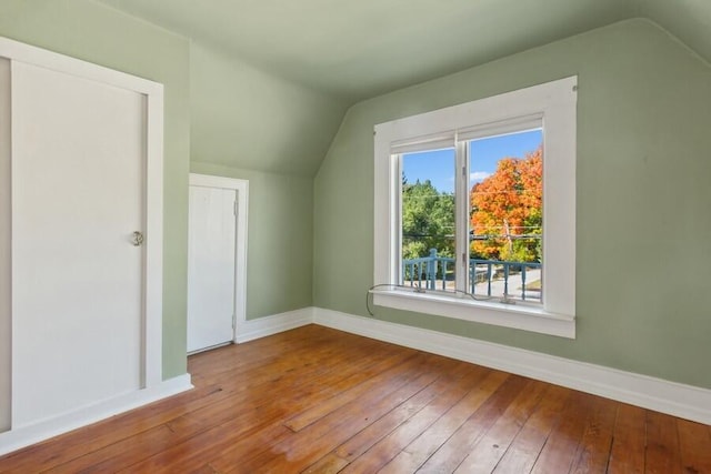 additional living space featuring hardwood / wood-style floors and vaulted ceiling