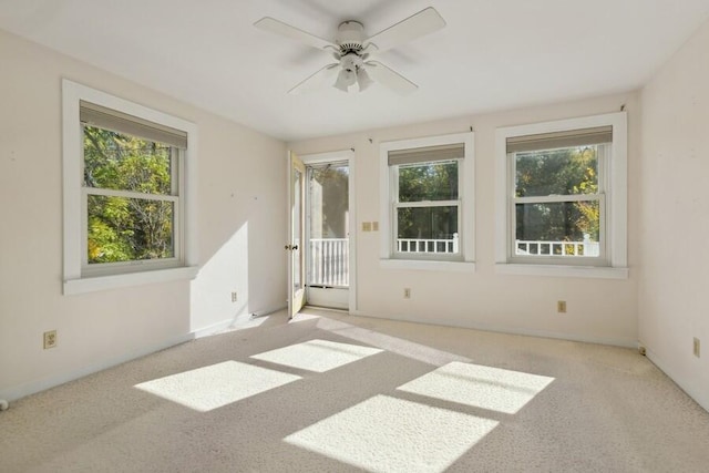 spare room featuring ceiling fan, plenty of natural light, and light colored carpet