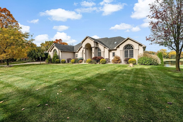 view of front facade with a water view and a front lawn