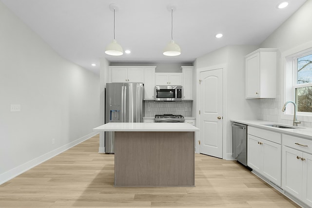 kitchen featuring a kitchen island, sink, white cabinetry, and stainless steel appliances