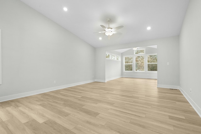 empty room featuring ceiling fan, light wood-type flooring, and vaulted ceiling