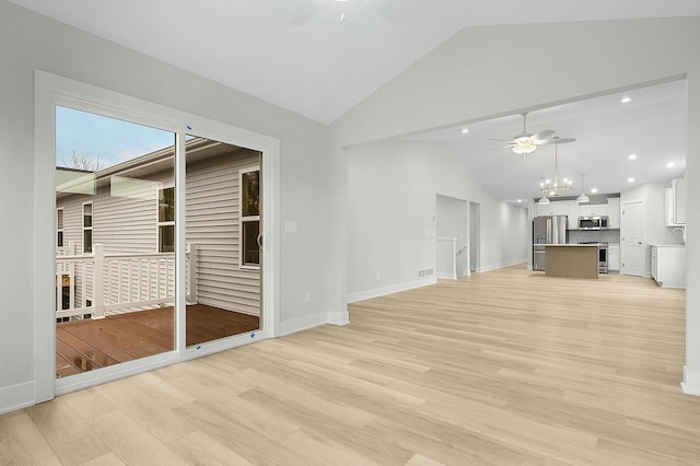 unfurnished living room with sink, light hardwood / wood-style floors, vaulted ceiling, and a notable chandelier