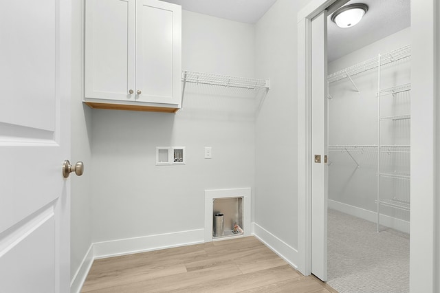 laundry area featuring cabinets, hookup for a washing machine, and light hardwood / wood-style flooring