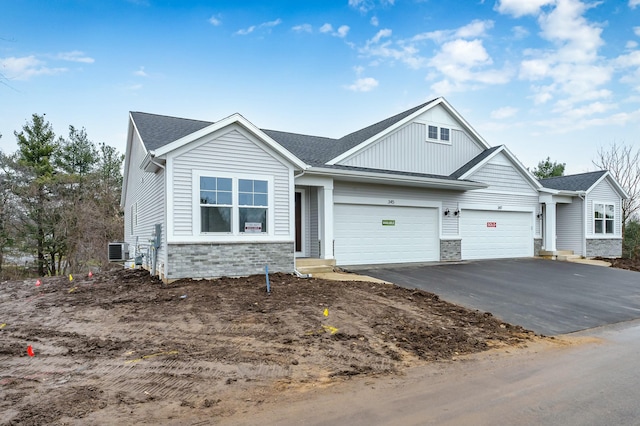 craftsman inspired home with a garage and central air condition unit