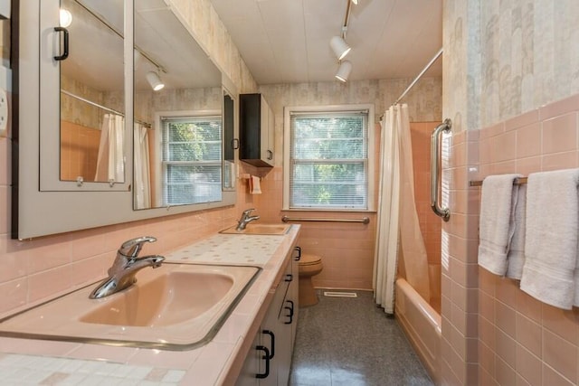 full bathroom with toilet, shower / bath combination with curtain, rail lighting, tile walls, and vanity