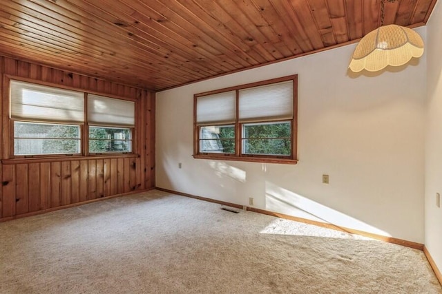 carpeted empty room with wood walls and wooden ceiling