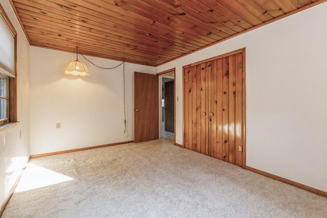 unfurnished room featuring carpet and wood ceiling