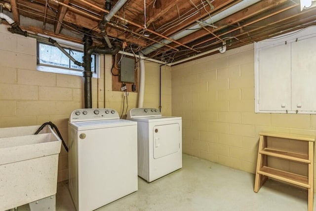 clothes washing area featuring sink, washer and dryer, cabinets, and electric panel