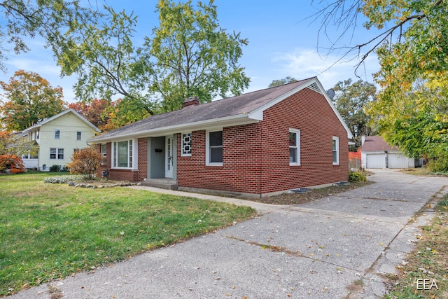 view of front of home featuring an outbuilding, a front yard, and a garage