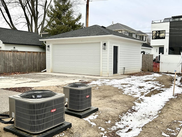 snow covered garage with cooling unit