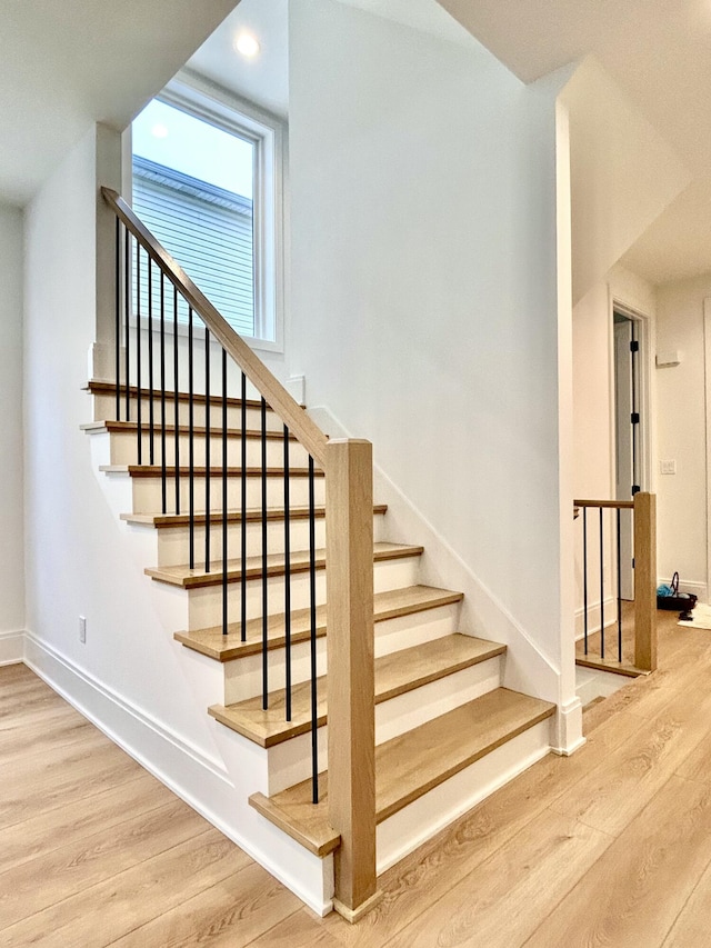 stairs featuring hardwood / wood-style floors